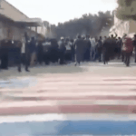 Studenten im Iran weigern sich, auf die amerikanische und israelische Fahne zu treten