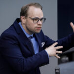 SPD-Politiker Helge Lindh bekämpft die Flut mit einem Sandsack